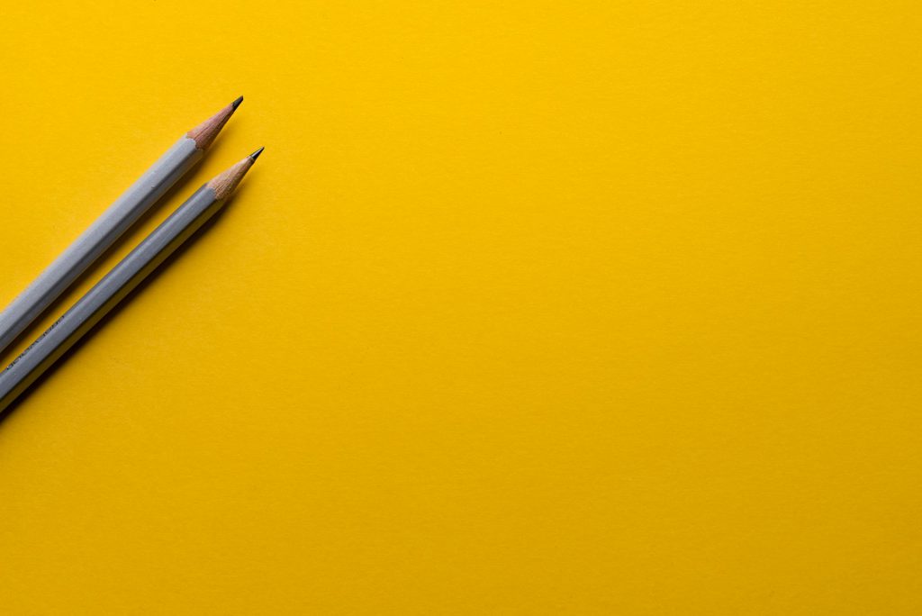yellow paper with two pencils to represent the start of work for branding